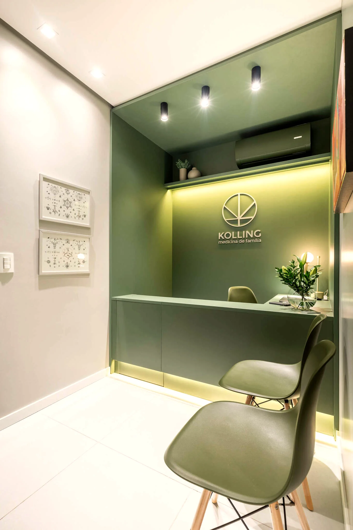 Recepção da clínica Kolling Medicina de Família, com balcão verde iluminado e identidade visual da marca
